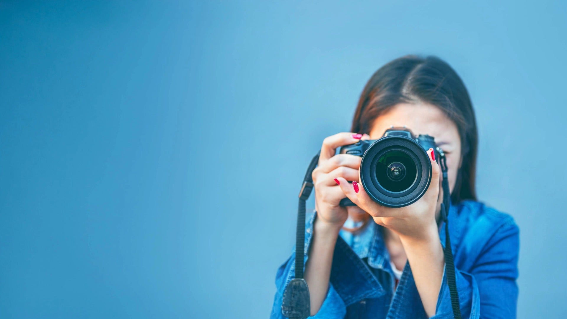 Person holding a camera directly toward the viewer — symbolizing capturing great photos for furniture listings