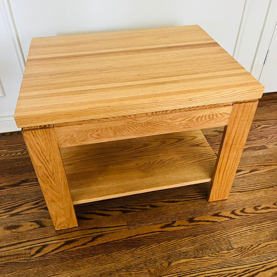 Pair of solid oak end tables with a clean, sturdy profile and practical lower shelves.