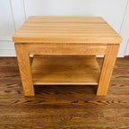 Pair of solid oak end tables with a clean, sturdy profile and practical lower shelves.