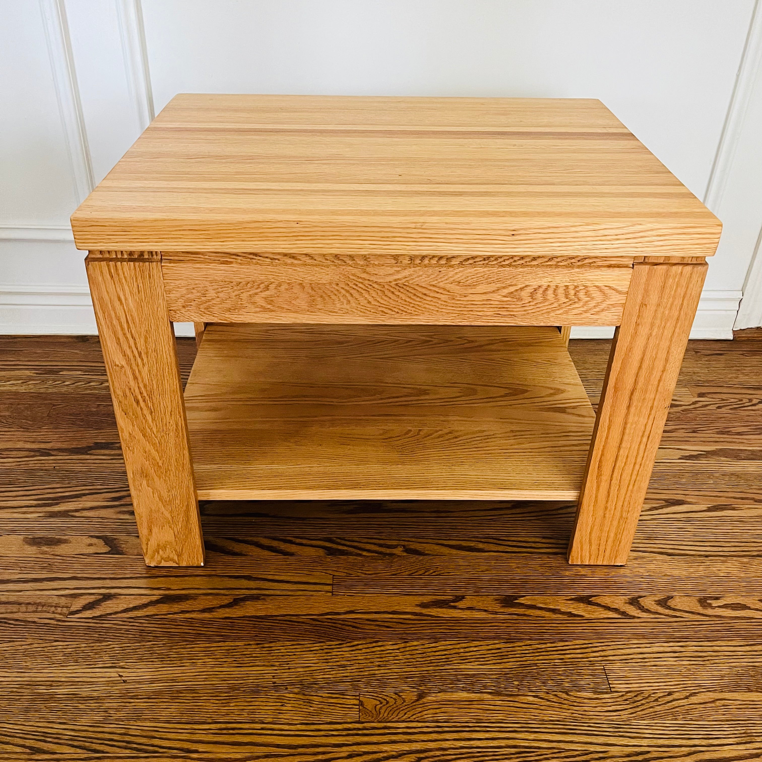 Pair of solid oak end tables with a clean, sturdy profile and practical lower shelves.