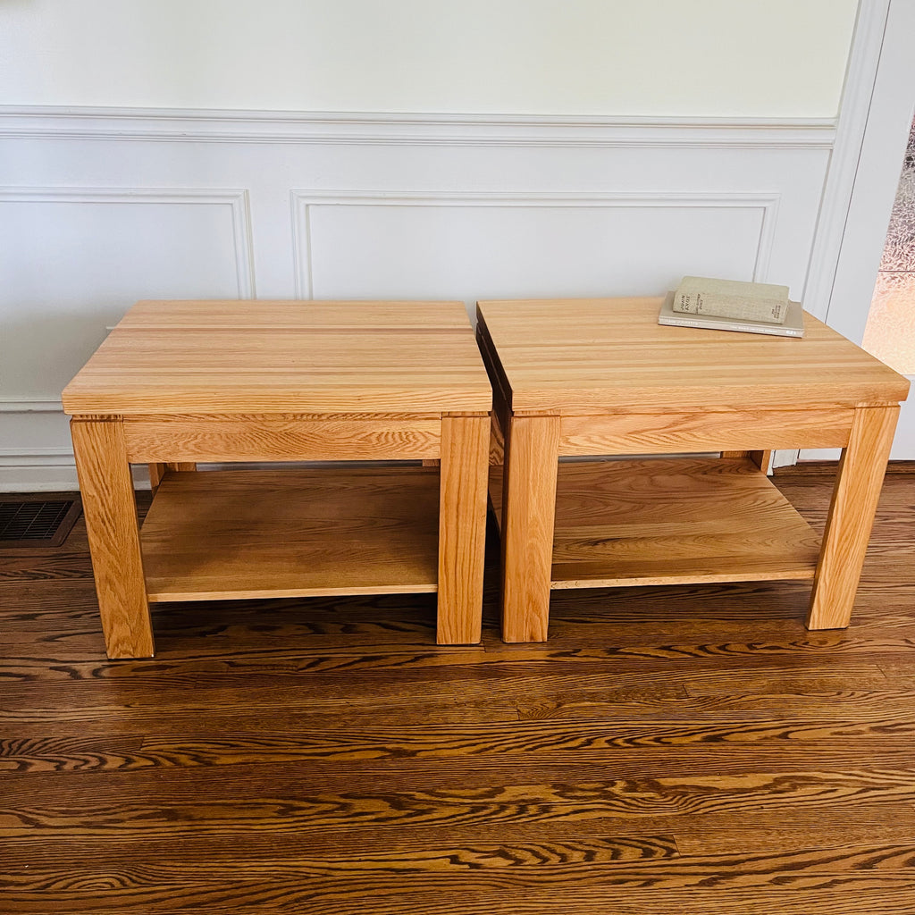 Pair of solid oak end tables with a clean, sturdy profile and practical lower shelves.